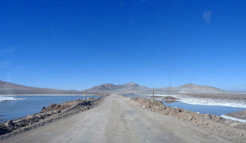 A road in the Atacama Desert surrounded by natural lagoons.